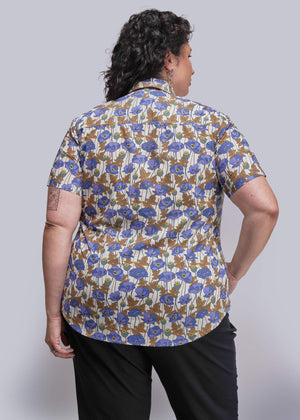 1X=Person wearing a floral patterned shirt with a plain background