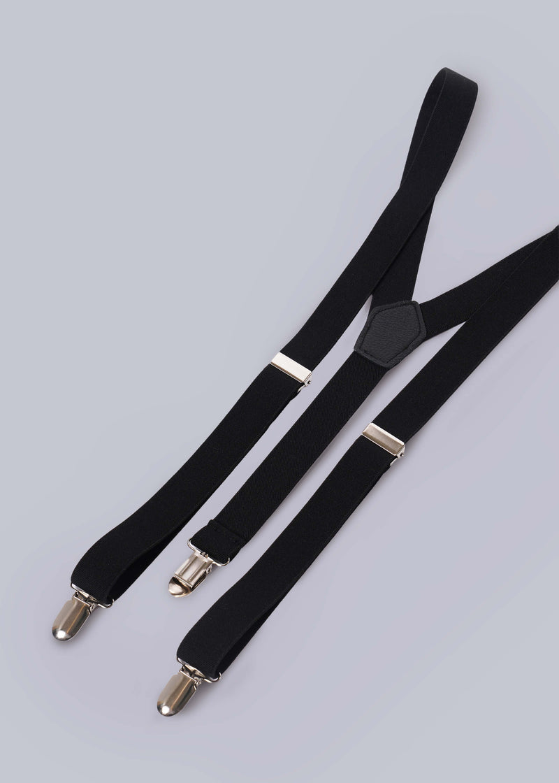 Flat lay of black suspenders on white background.