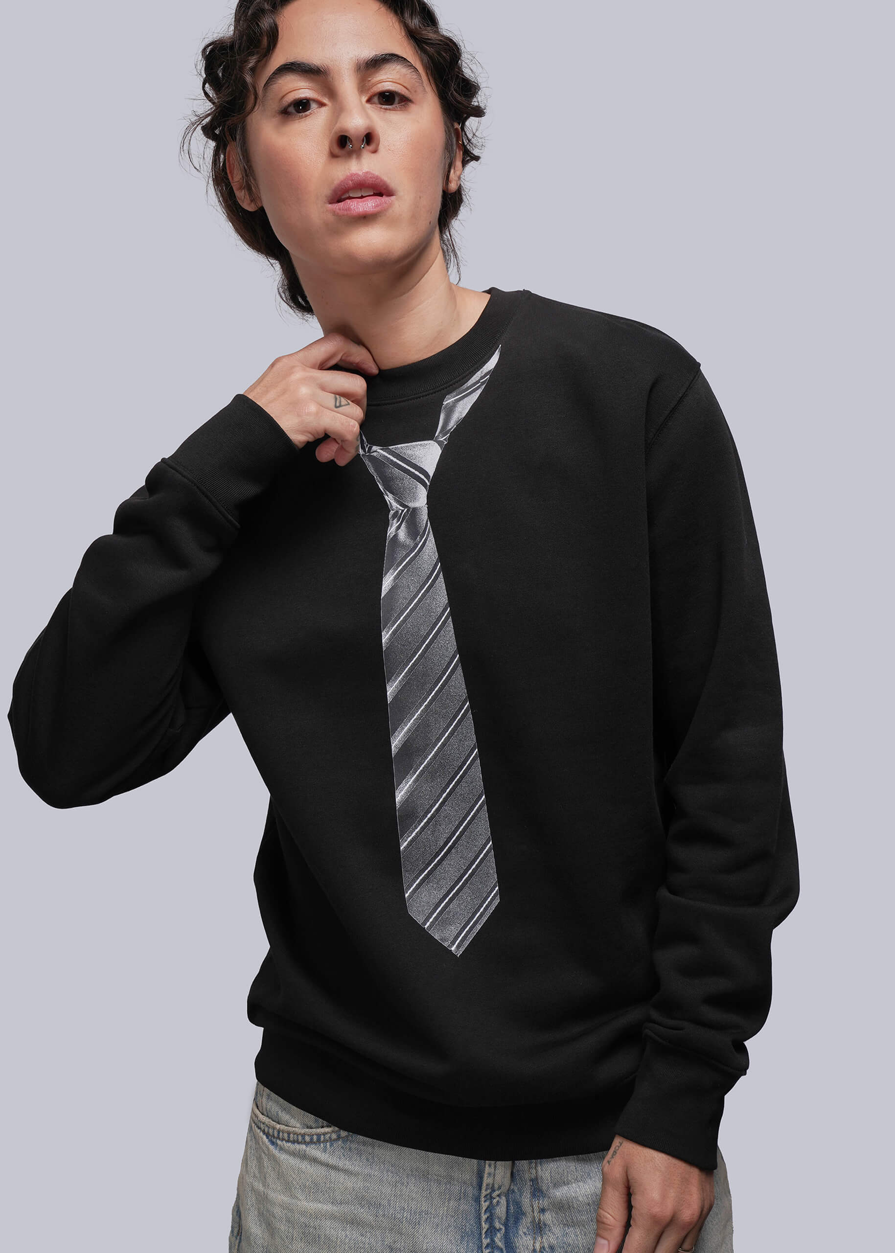 S=Person wearing a black sweatshirt with a tie design on a plain background