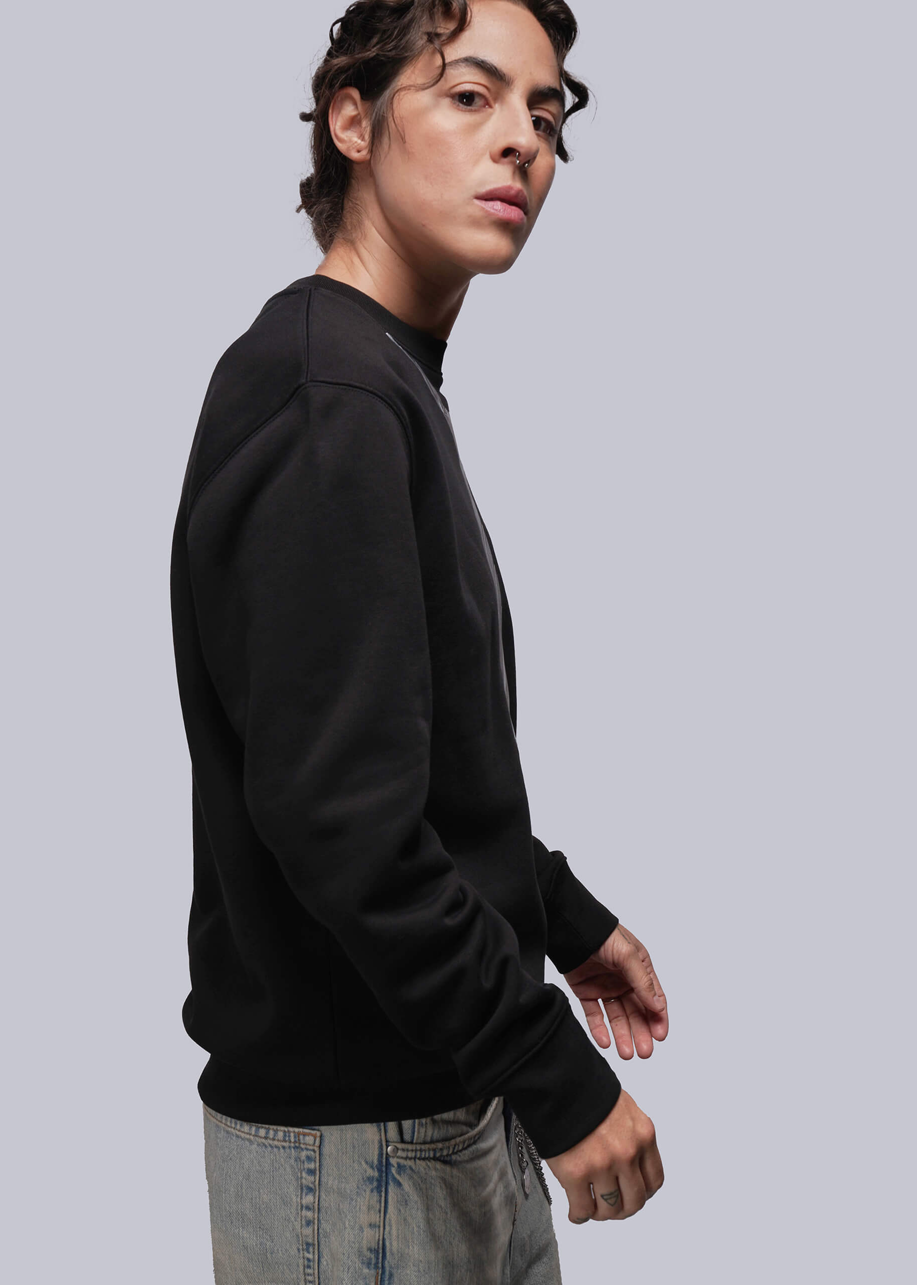 S=Person wearing a black sweatshirt against a gray background