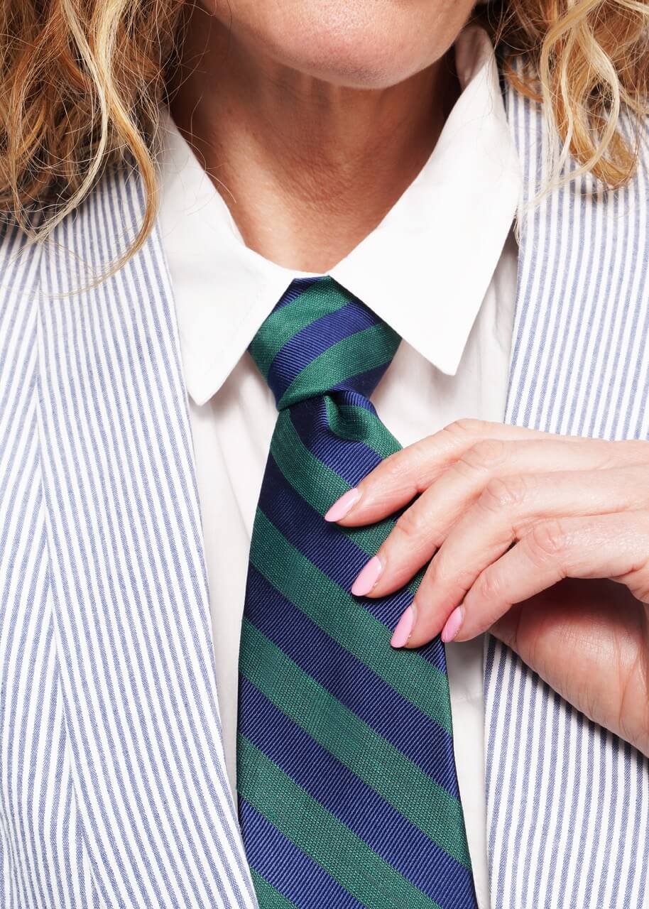 Close up of model's neck area showing details of blue and green tie.