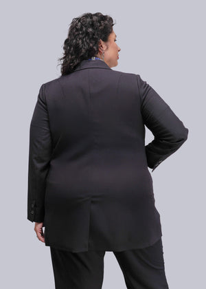 1X=Person wearing a black suit against a plain background