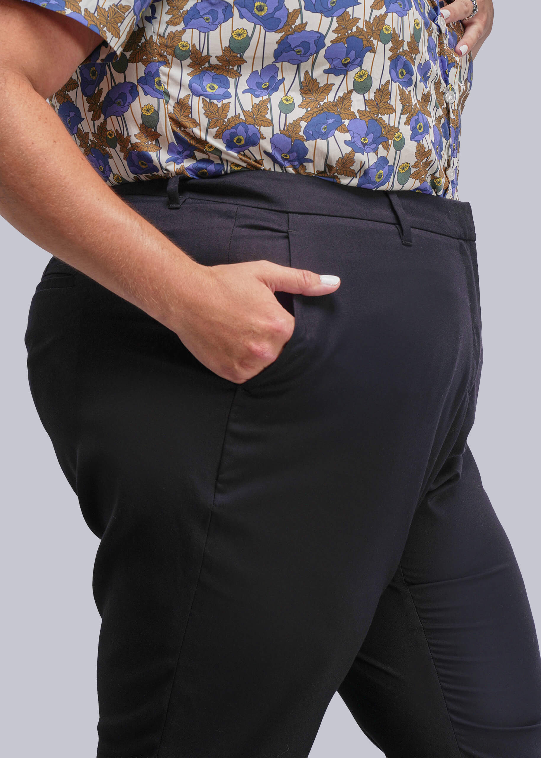 1X=Person wearing a floral shirt and black pants on a plain background