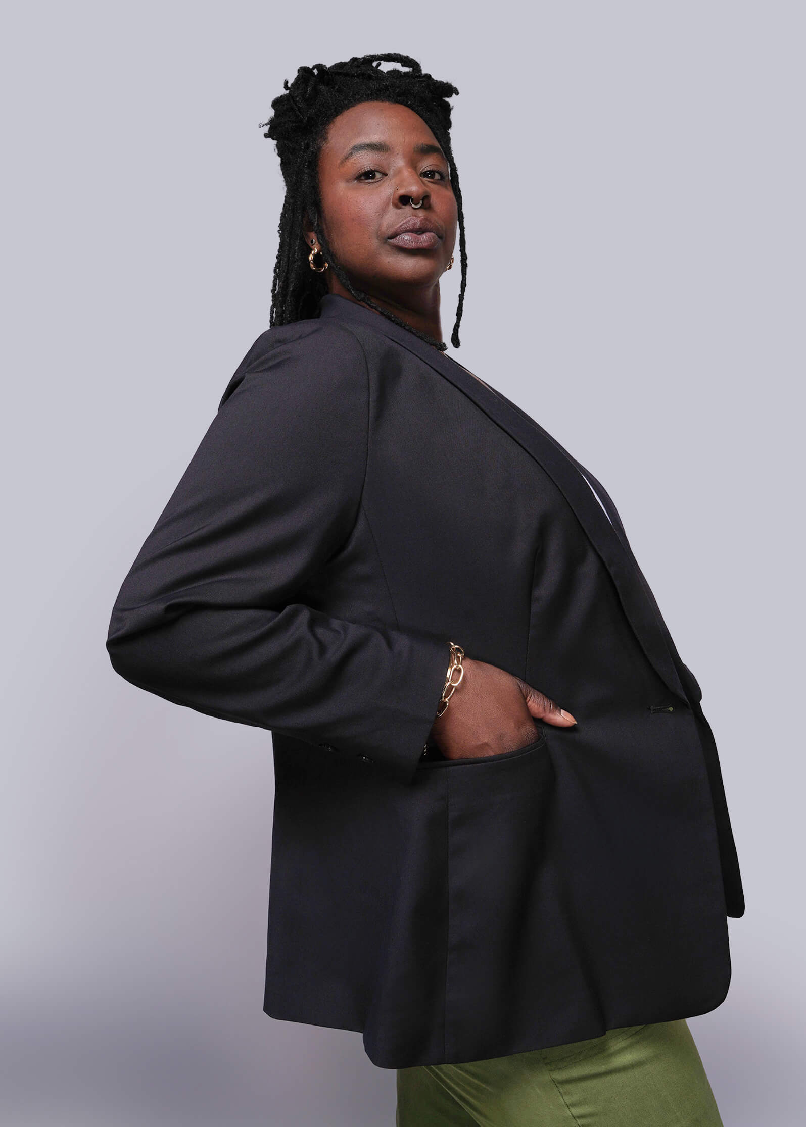 1X=Person wearing a black blazer against a plain background