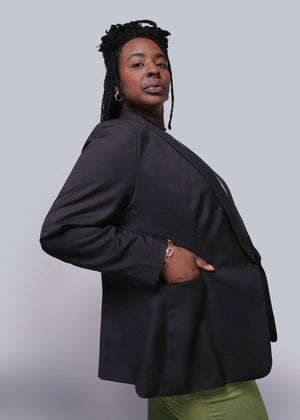 1X=Person wearing a black blazer against a plain background