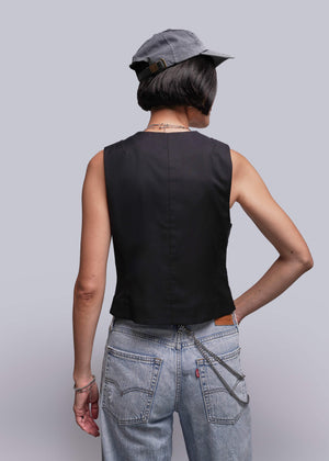 S=Person wearing a black sleeveless top and light blue jeans with a gray cap on a plain background