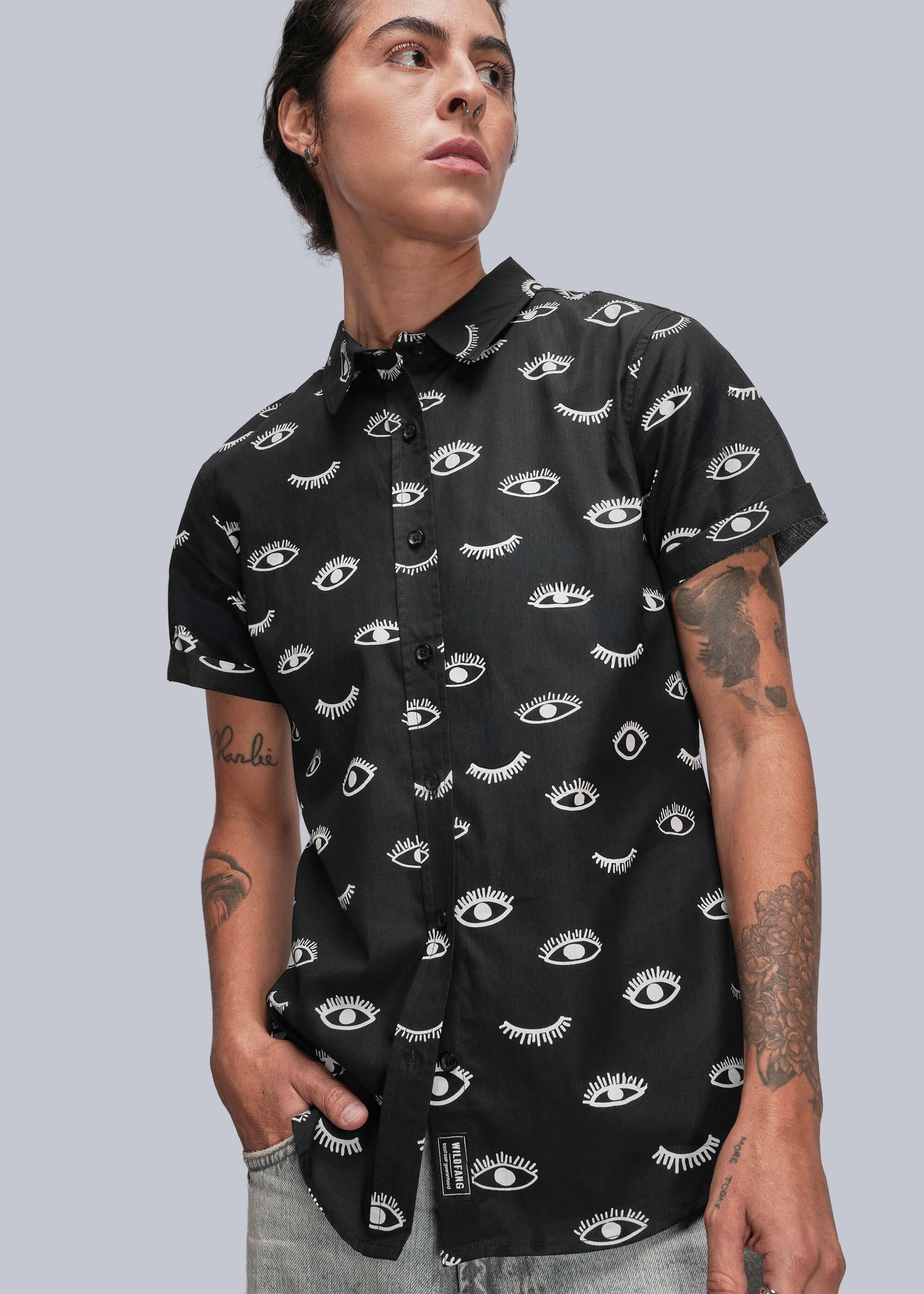 Person wearing a black short-sleeve shirt with white pattern against a gray background