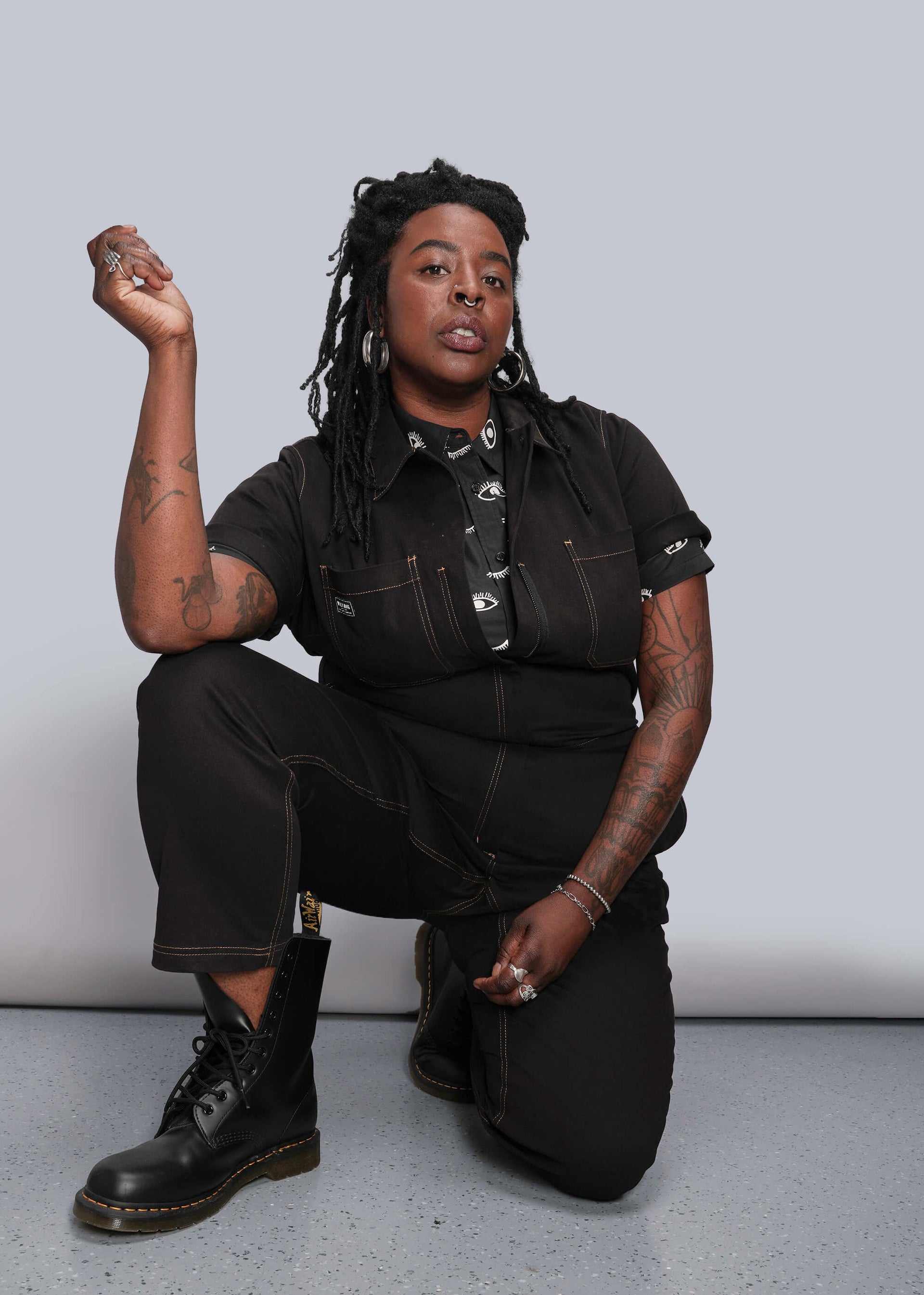 1X=Person wearing a black coverall with a neutral background