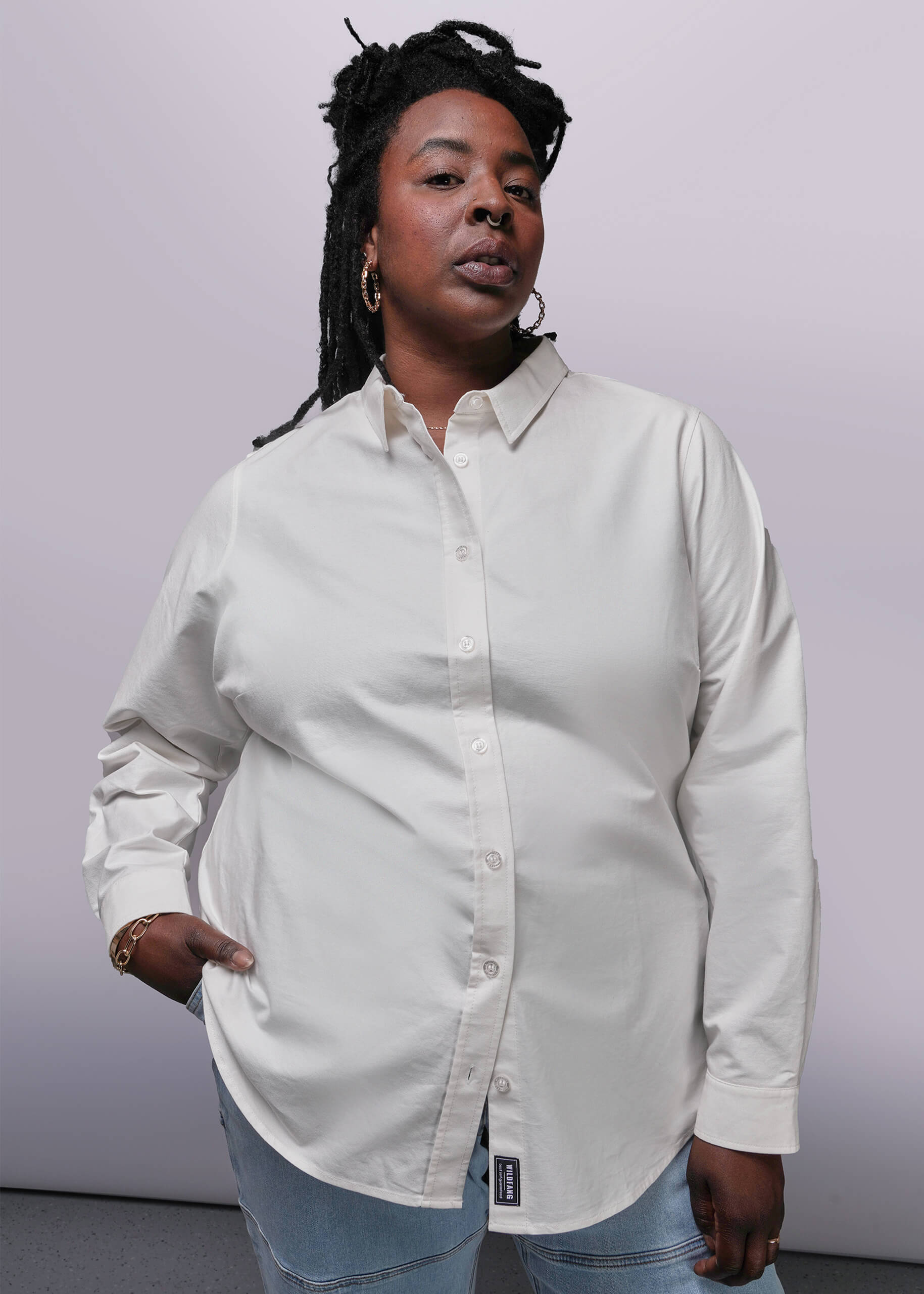 1X=Person wearing a white long sleeve button-up shirt against a plain background