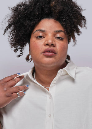1X=Person wearing a white shirt with a plain background