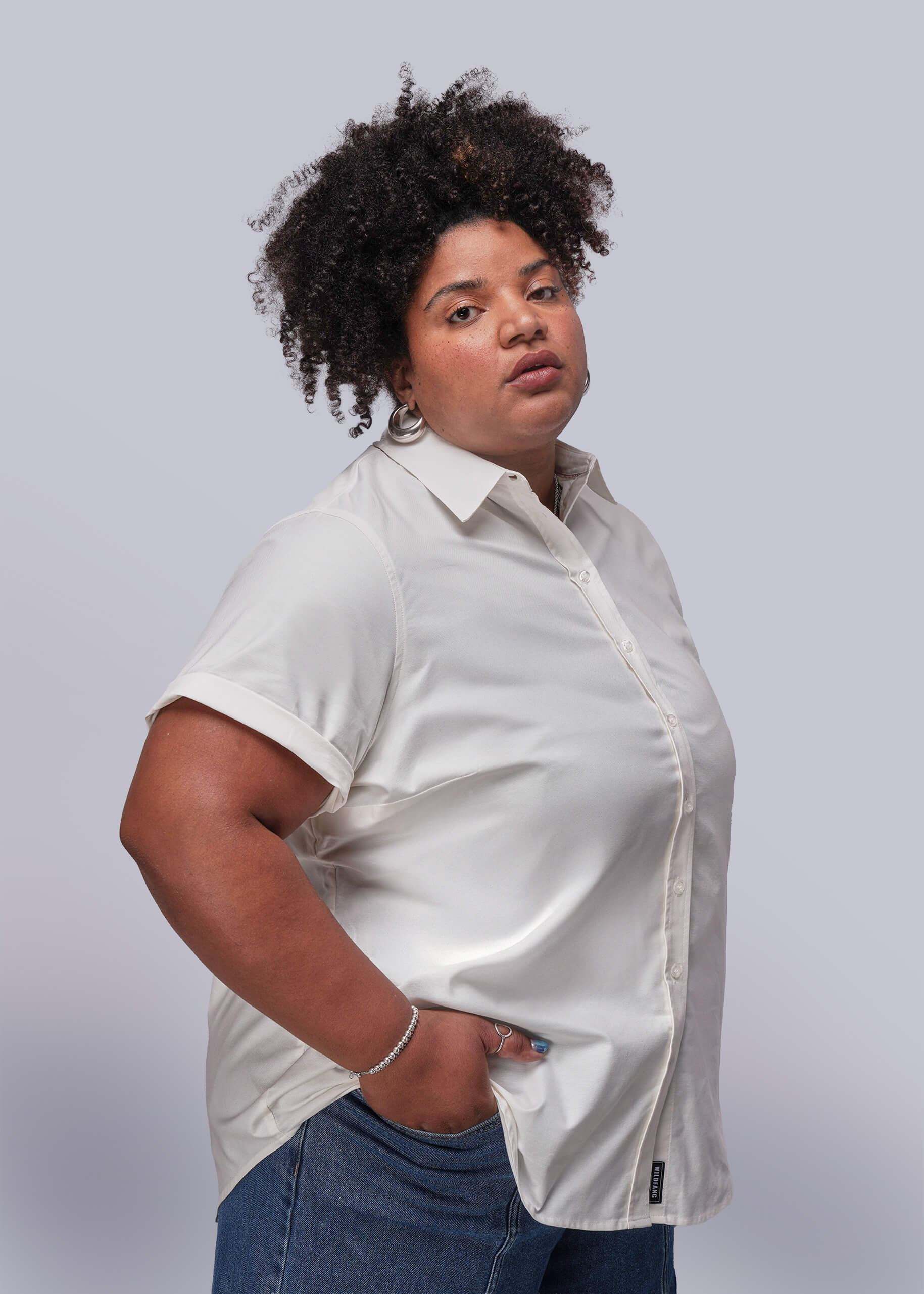 1X=Person wearing a white shirt and blue jeans against a plain background