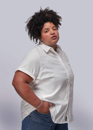1X=Person wearing a white shirt and blue jeans against a plain background