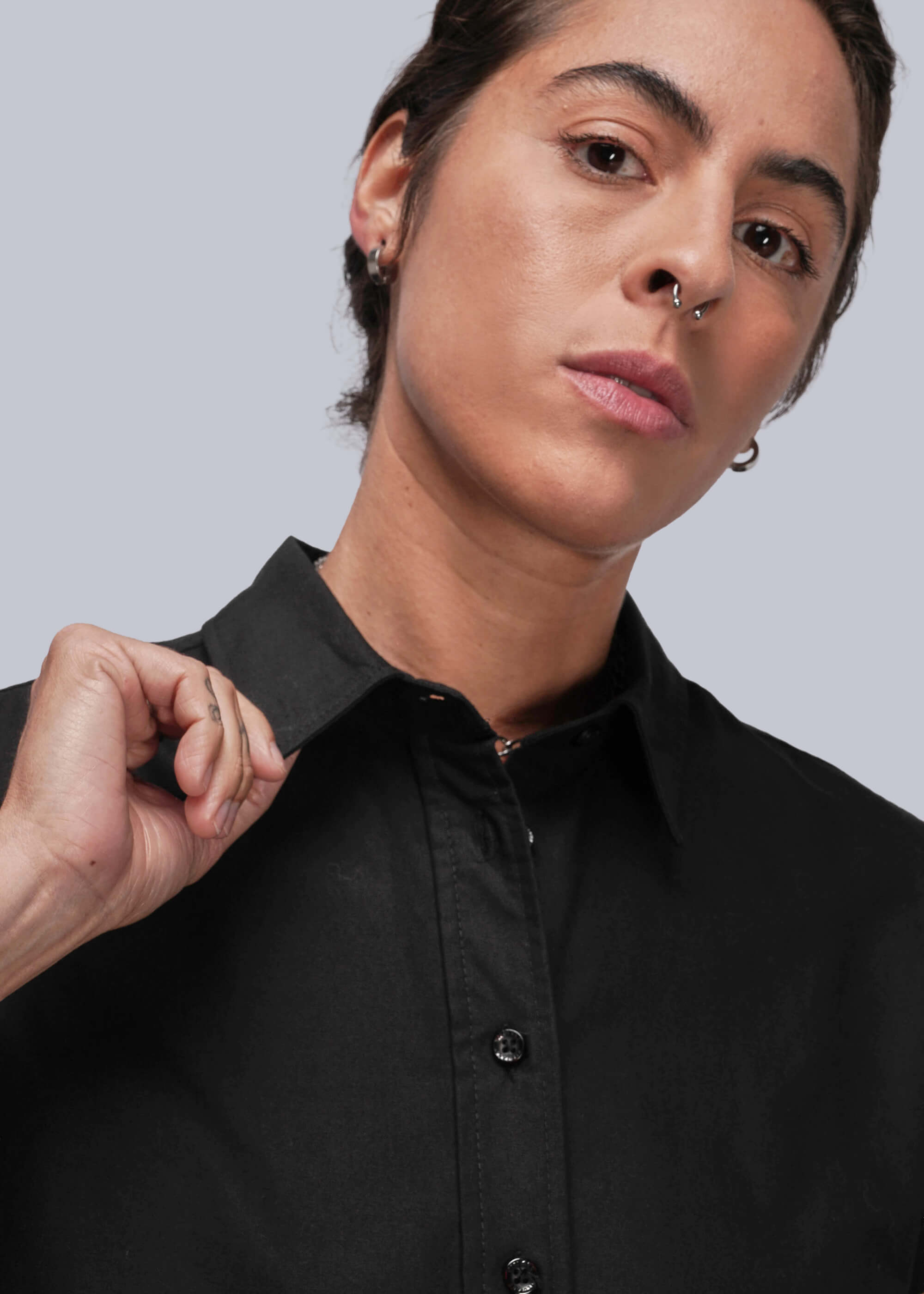 Close up of person wearing a black shirt against a light gray background