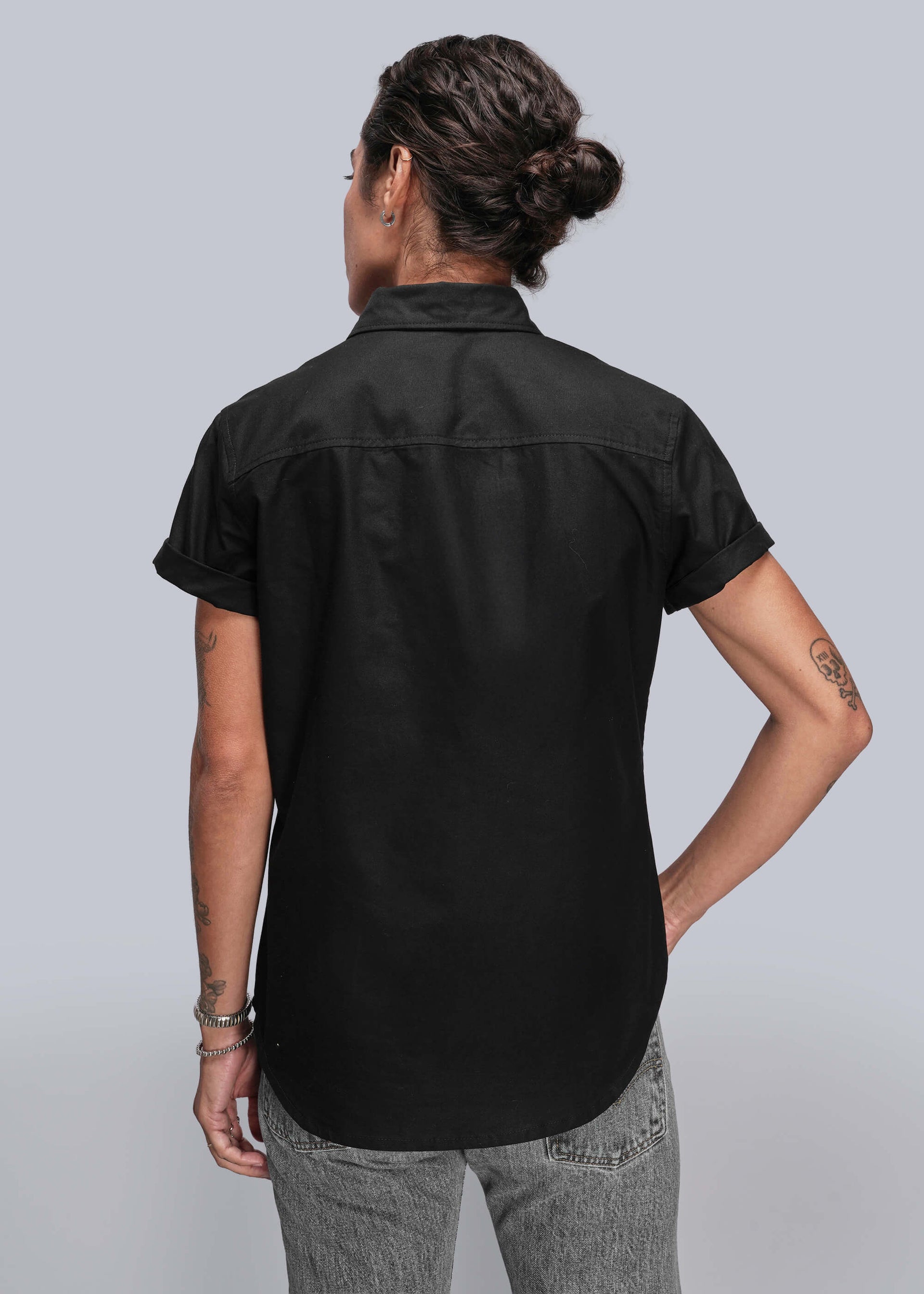 S=Person wearing a black short-sleeve shirt on a gray background