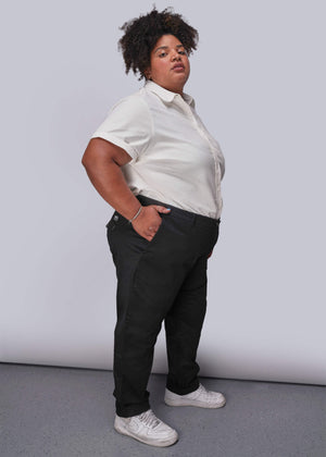 1X=Person wearing a white button up shirt and black pants against a plain background