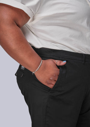 1X=Person wearing a white shirt and black pants with a plain background