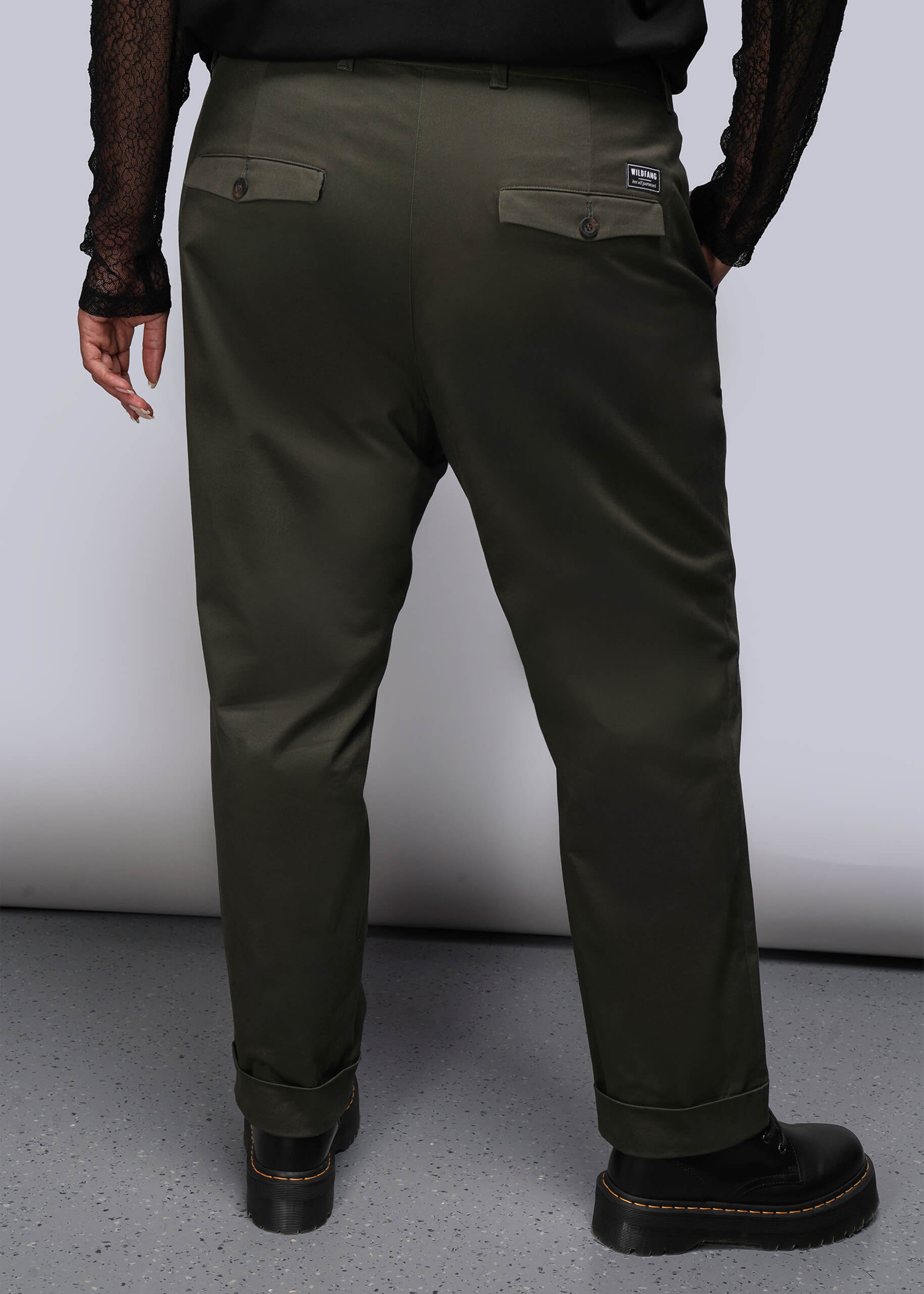 1X=Person wearing olive green pants with a plain background