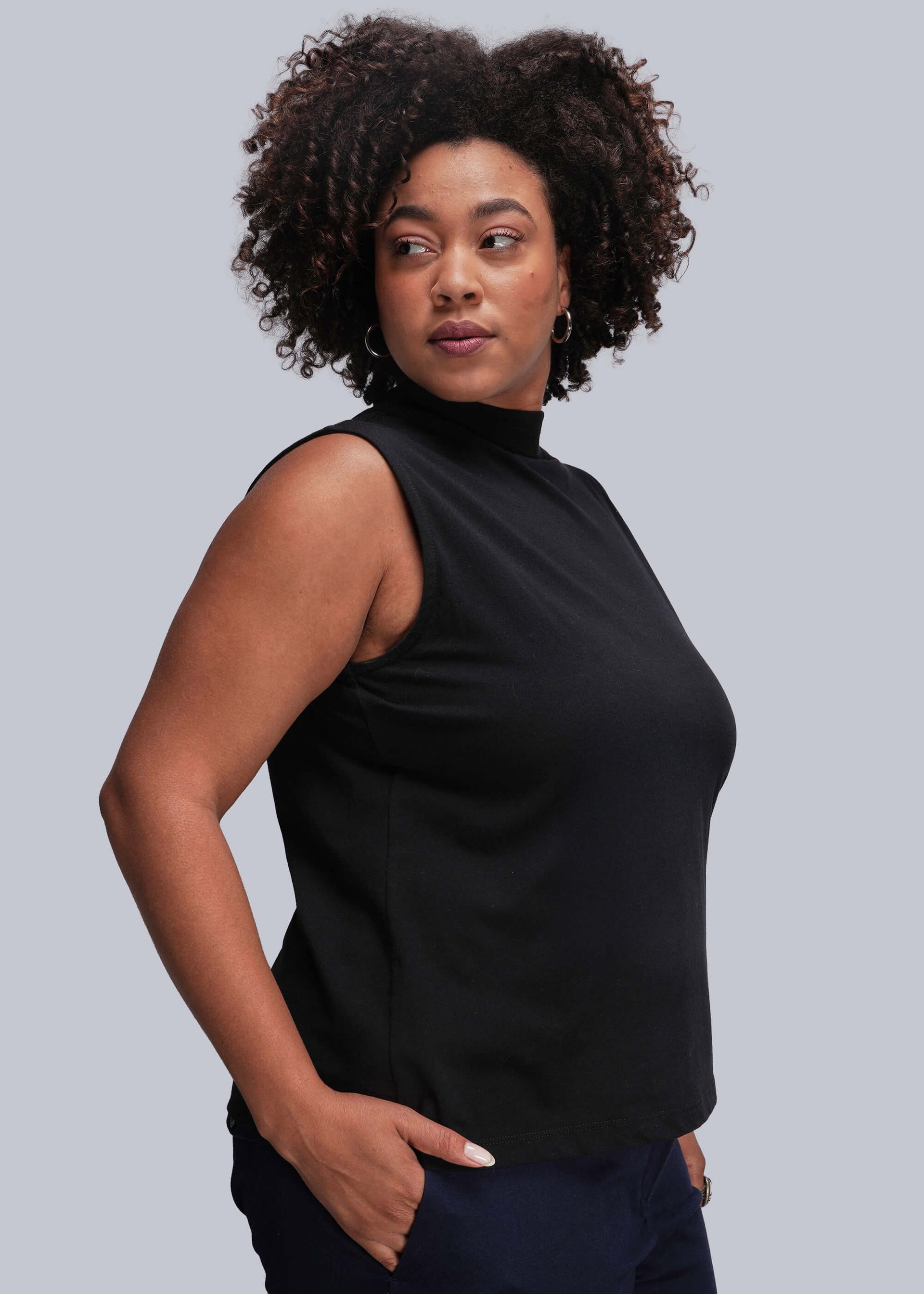 1X=Person wearing a black sleeveless top against a gray background