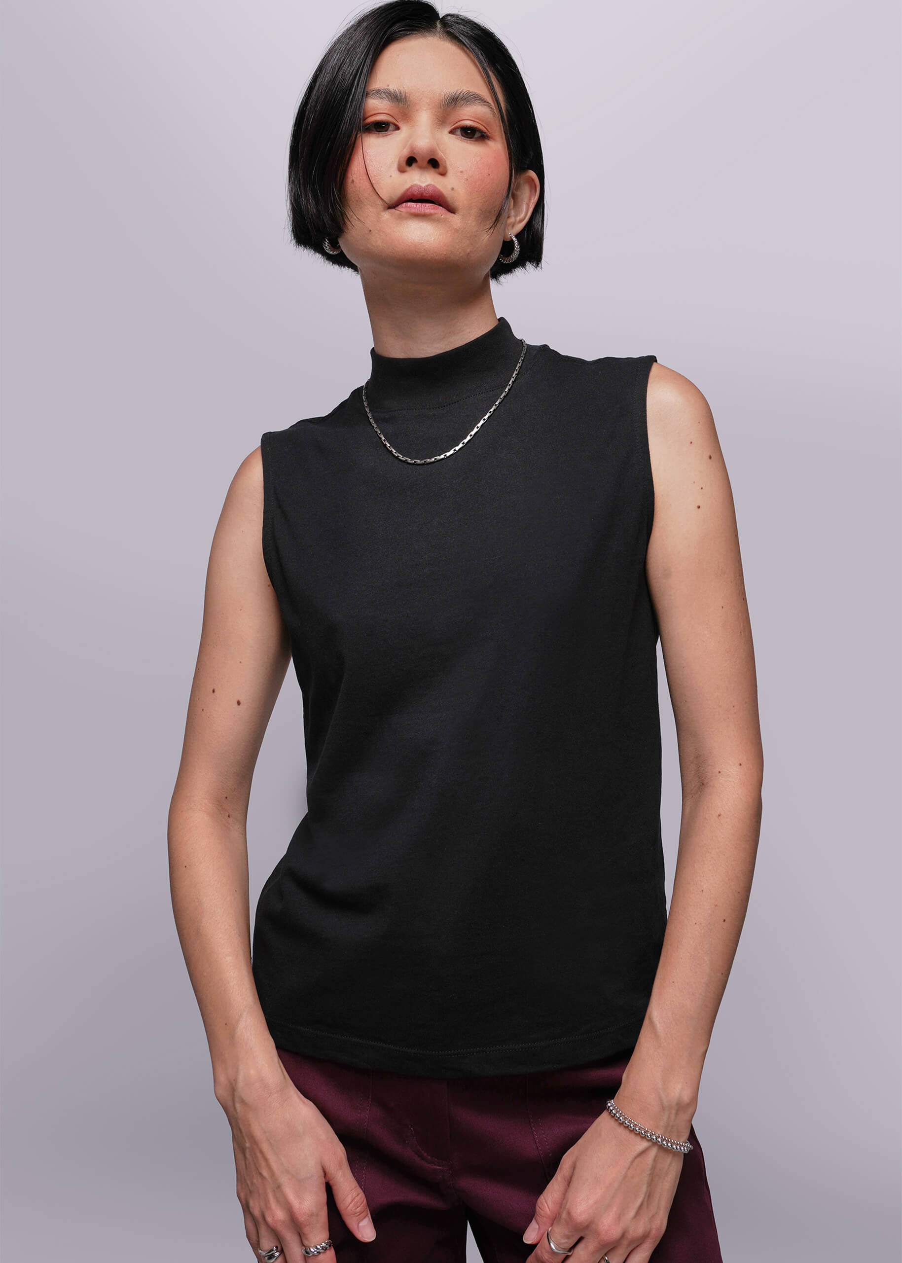 S=Person wearing a black sleeveless top against a plain background