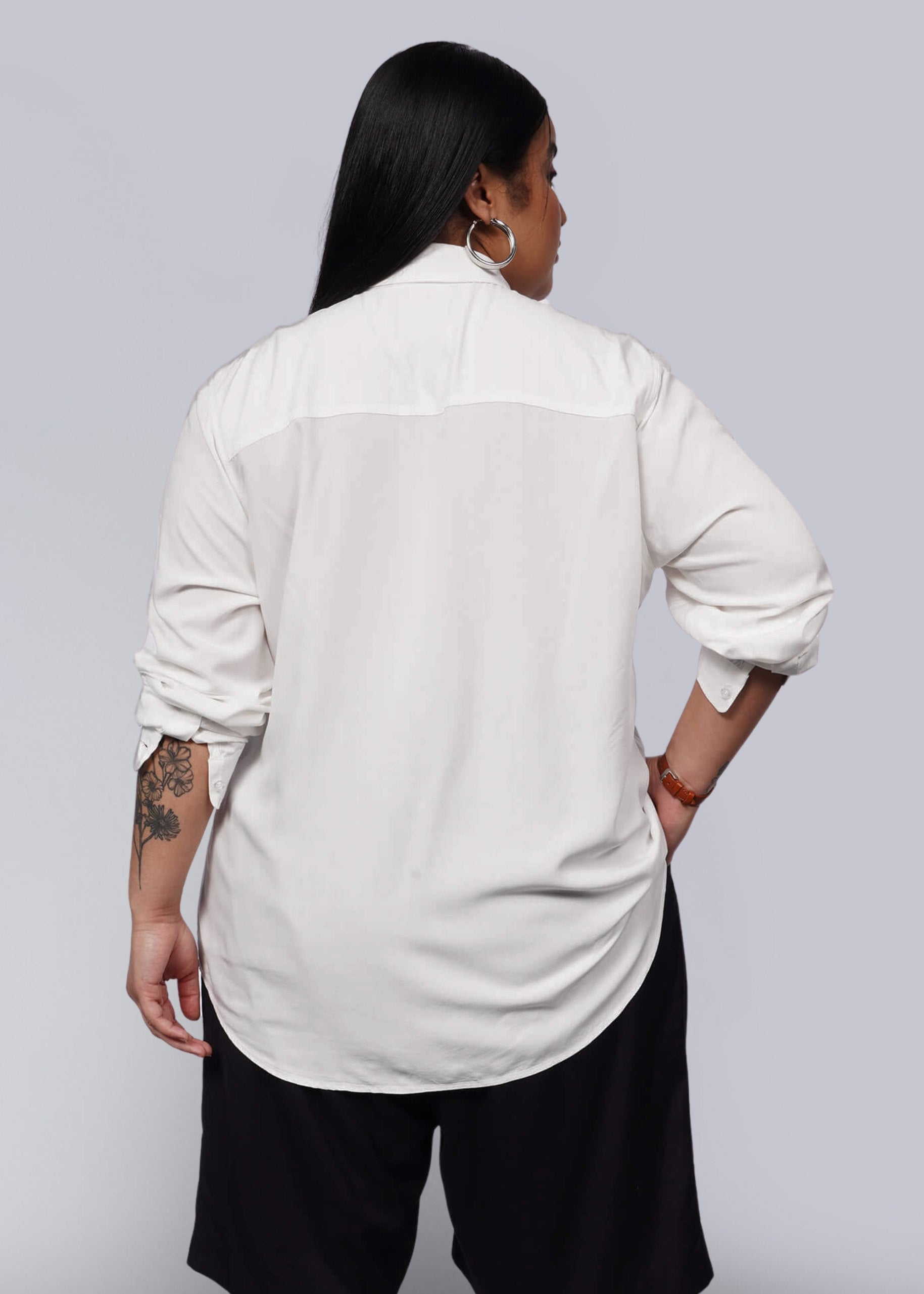 1X=Person wearing a white shirt and black pants on a plain background