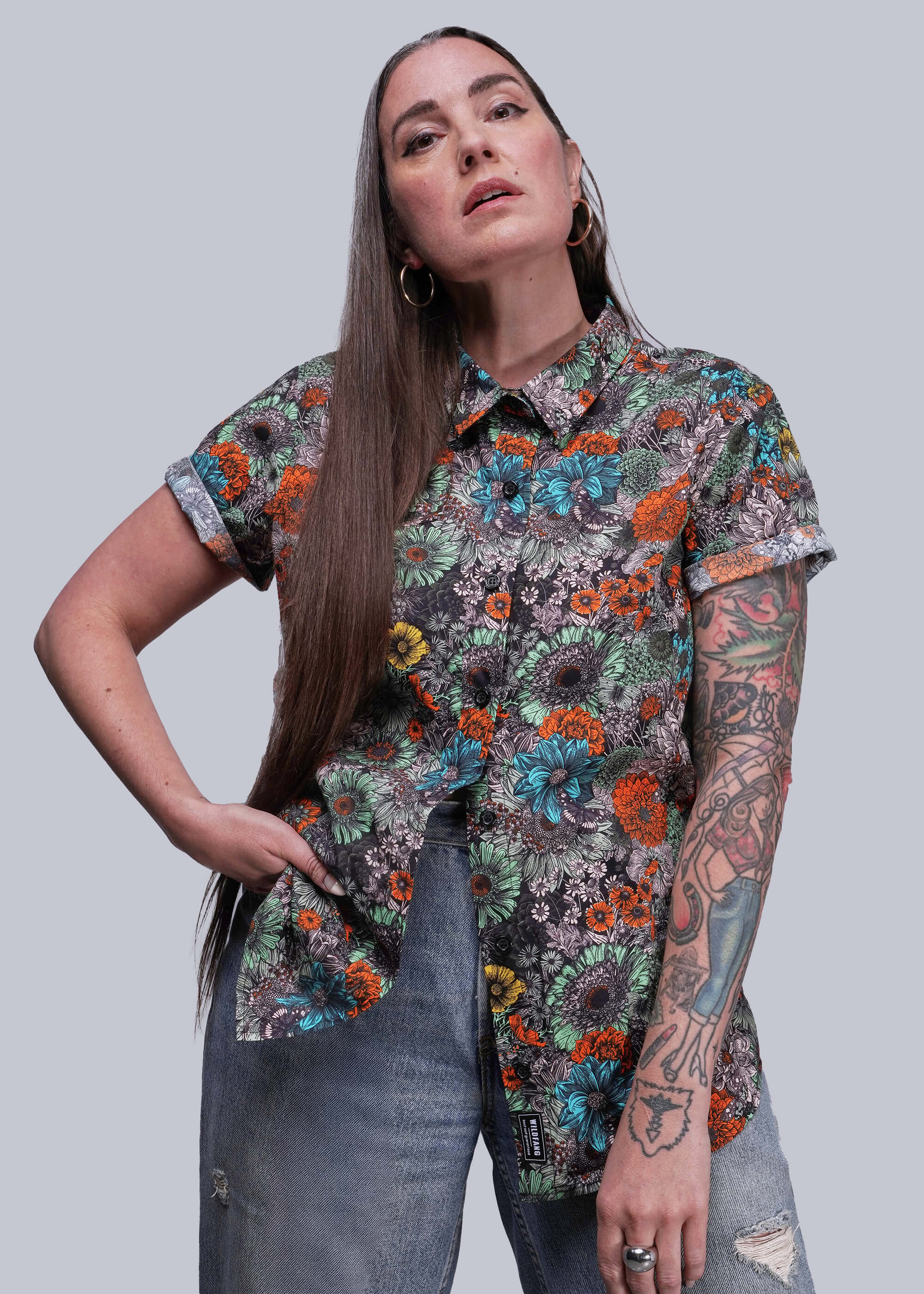 Woman wearing a colorful floral shirt against a plain background