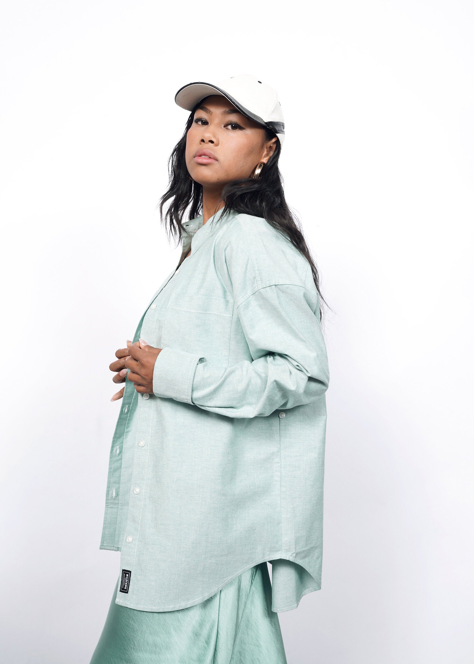 Model wearing The Essential Long Sleeve Oversized Convertible Oxford Button Up in Emerald/White