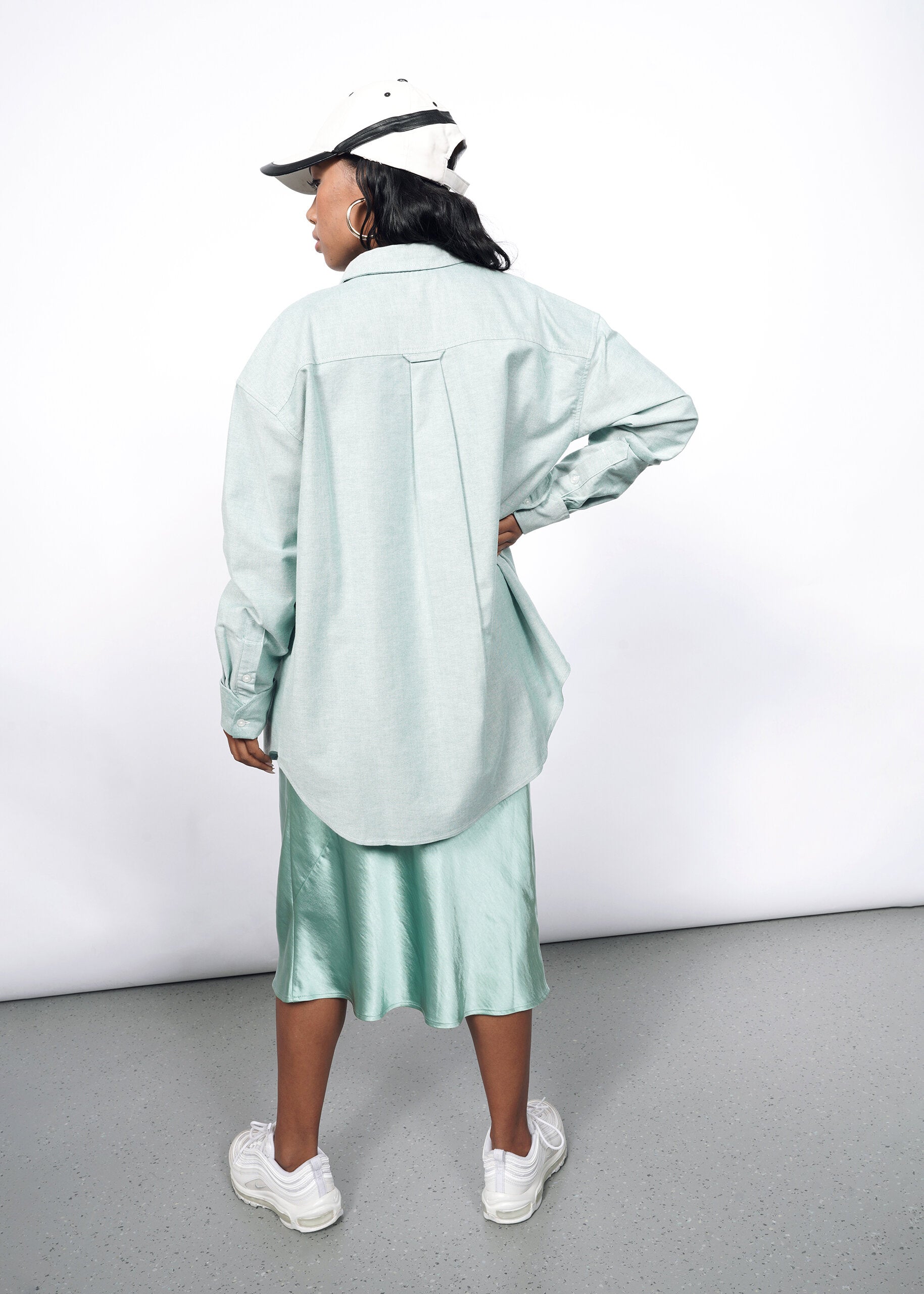 Model wearing The Essential Long Sleeve Oversized Convertible Oxford Button Up in Emerald/White