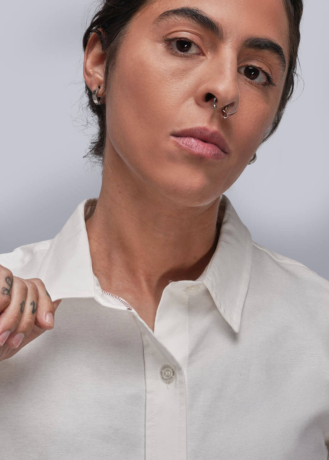 Person wearing a white shirt against a plain background