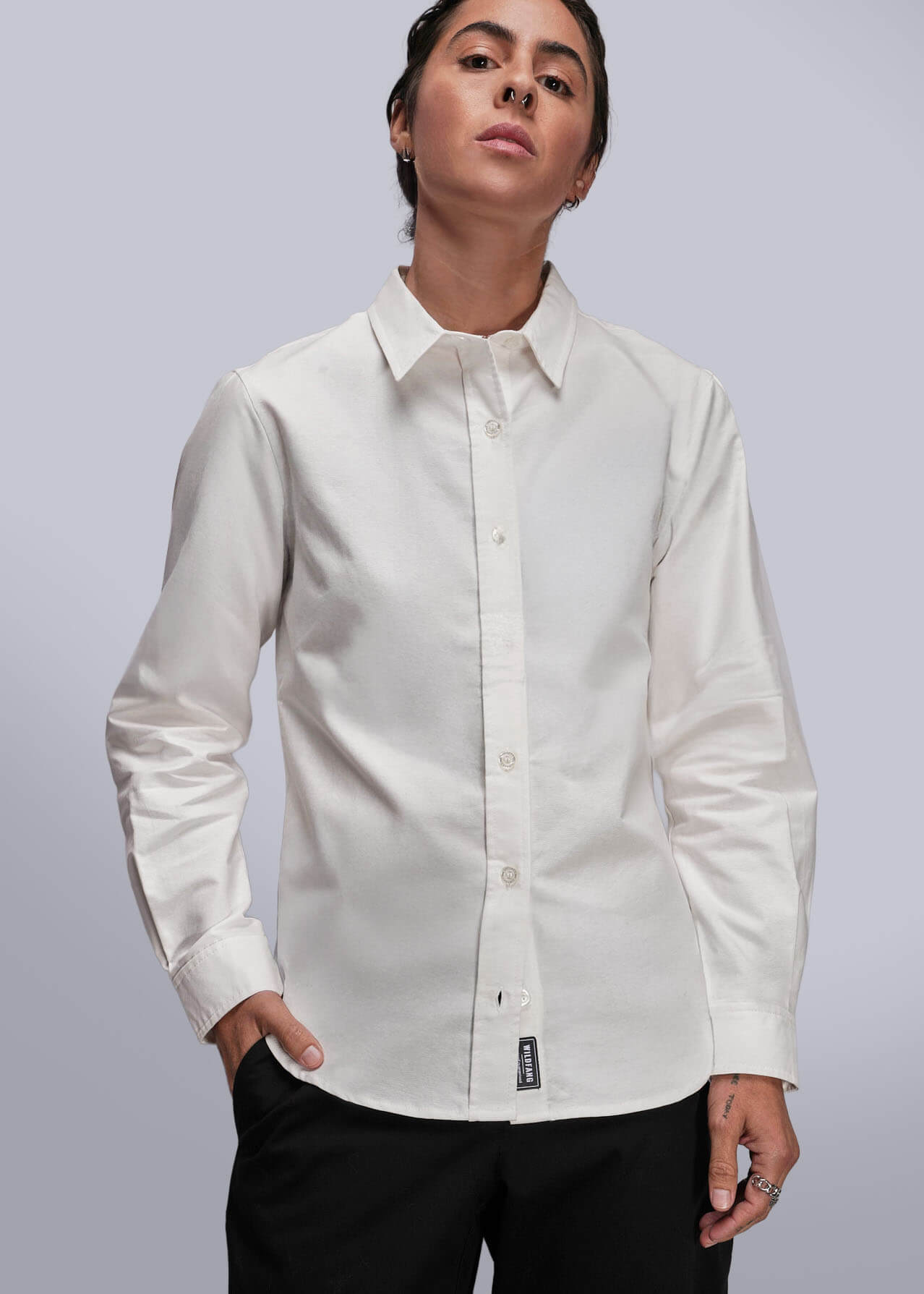 Person wearing a white dress shirt with a gray background