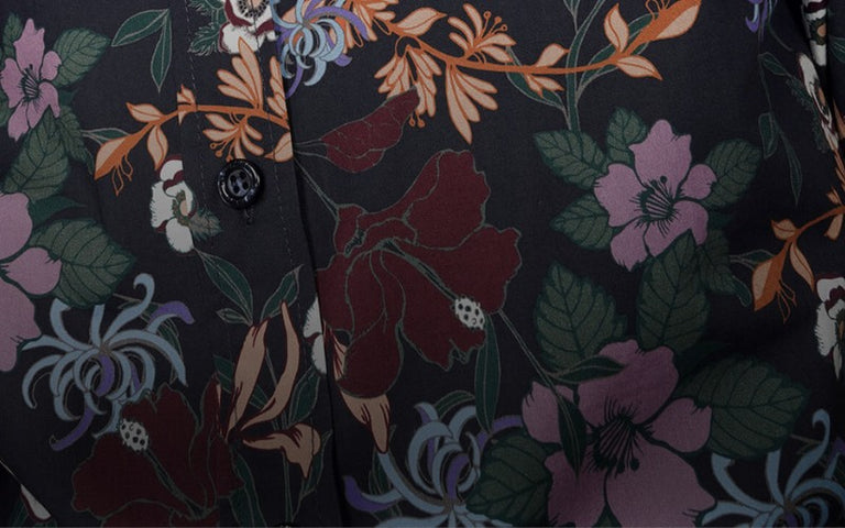 Close up of purple, green, orange, and red toned floral print on button up