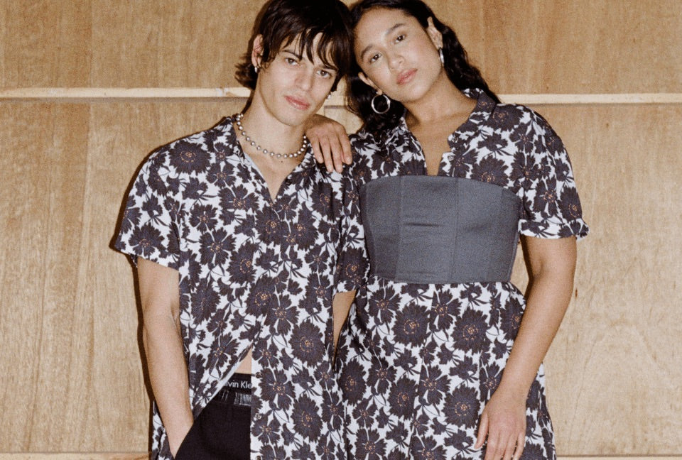 Two models stand in front of light wood background wearing WILDFANG pieces exclusively available at Urban Outfitters.