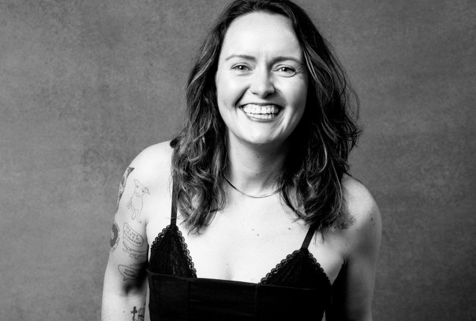 Emma Mcilroy, CEO of Wildfang, smiles while looking at camera against plain background.