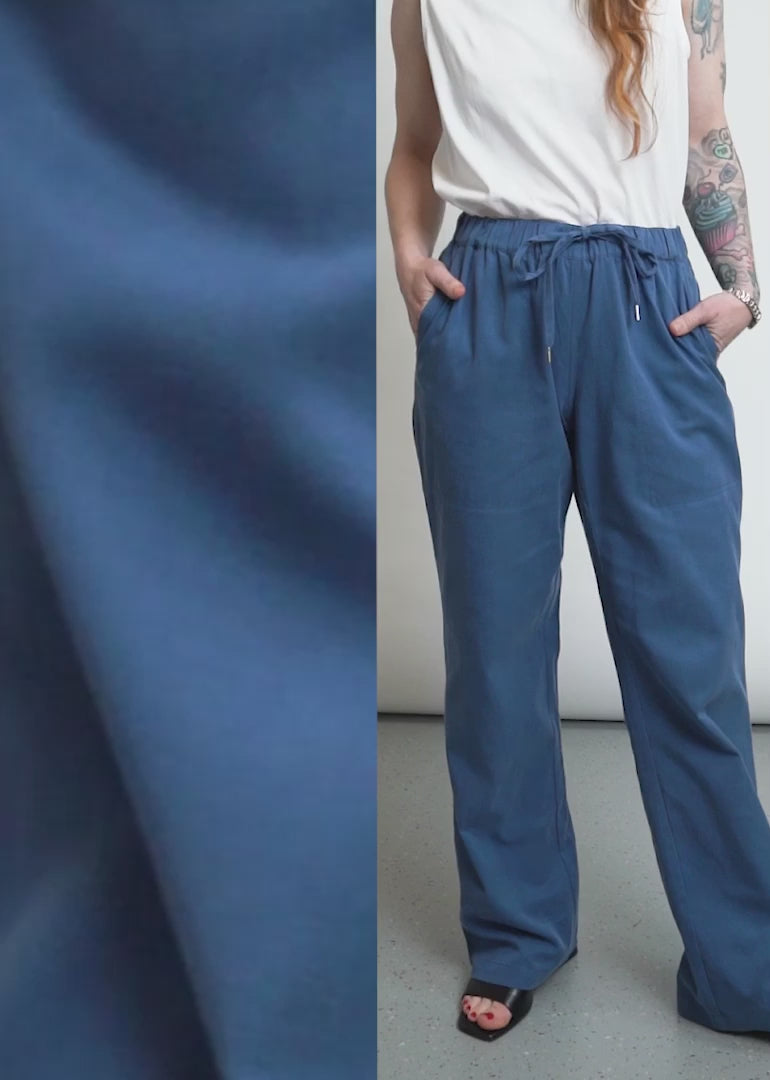 This video shows The Everyday Elastic Waist Paint in Oxford Blue on two models. Close up shots show the drawstring waist, the side and back pockets, and the elastic waistband. The video ends with a split screen side by side shot of the two models wearing the pant to show how it fits on different bodies.