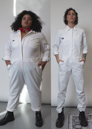 Video of two model of two different sizes wearing The Essential Long Sleeve Herringbone Coverall. Video featured close ups of zipper, side and back pockets, collar button, herringbone fabric, and stretch,
