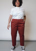 Video shows model wearing The Essential Trouser in Cinnamon. Shows close ups of from and back pockets and bottom cuff. Model kicks leg and spins to show comfortable fabric with stretch.