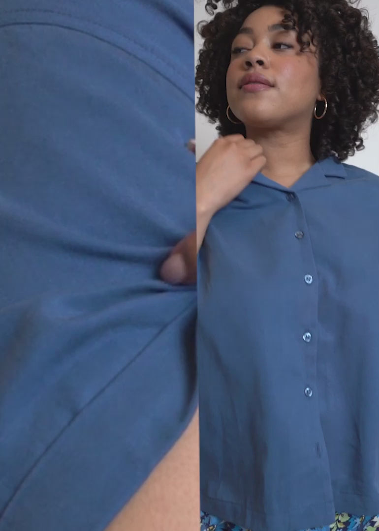 Video shows models of two different sizes wearing The Everyday Camp Button Up in Oxford Blue. Close up shots show the folded sleeve, the camp collar, the buttons, and the Wildfang tag. Video ends with side by side split screen of models to show how button up fits on different body types.
