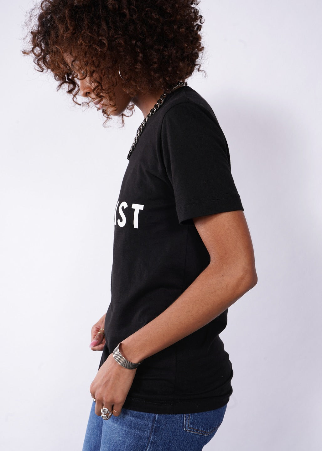 Model wearing Wild Feminist® Tee in black, facing left
